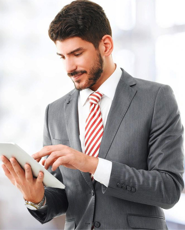 A man in a suit and tie using a tablet.